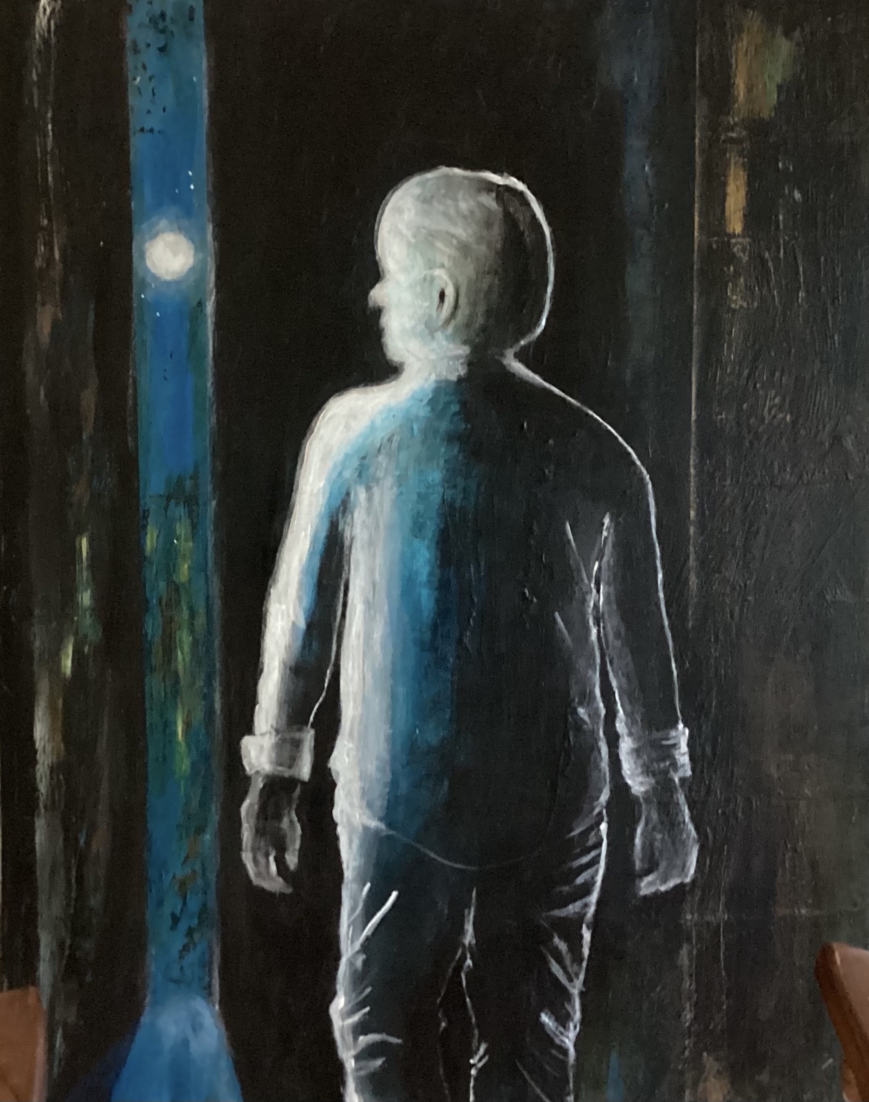 Deep in the city a man in sihlouette turns to watch the moon.
